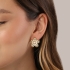 BR-02205-BRINCO BANHADO A OURO 18K EM FORMATO DE FLOR COM DETALHES TEXTURIZADOS E PÉROLA