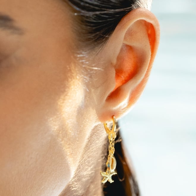 AQ-00186 BRINCO BANHADO A OURO 18K EM FORMATO DE ARGOLA COM PINGENTES DE BÚZIO E ESTRELA DO MAR