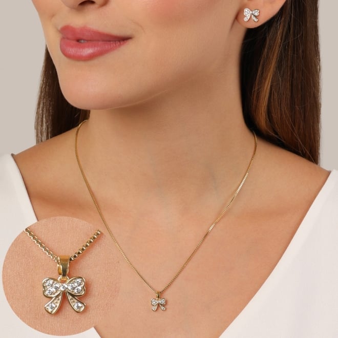 CJS-00112 CONJUNTO BANHADO A OURO 18K COM DESIGN DELICADO E FEMININO,COLAR COM PINGENTE EM FORMATO DE LAÇO CRAVEJADO EM ZIRCÔNIAS CRISTAL